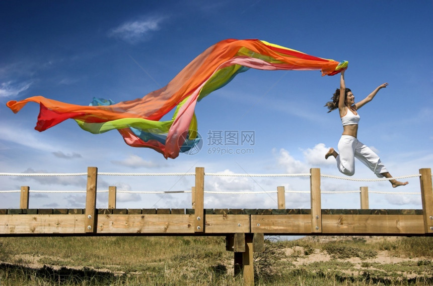 新鲜年轻美丽的女人用围巾跳跃女孩跑步图片