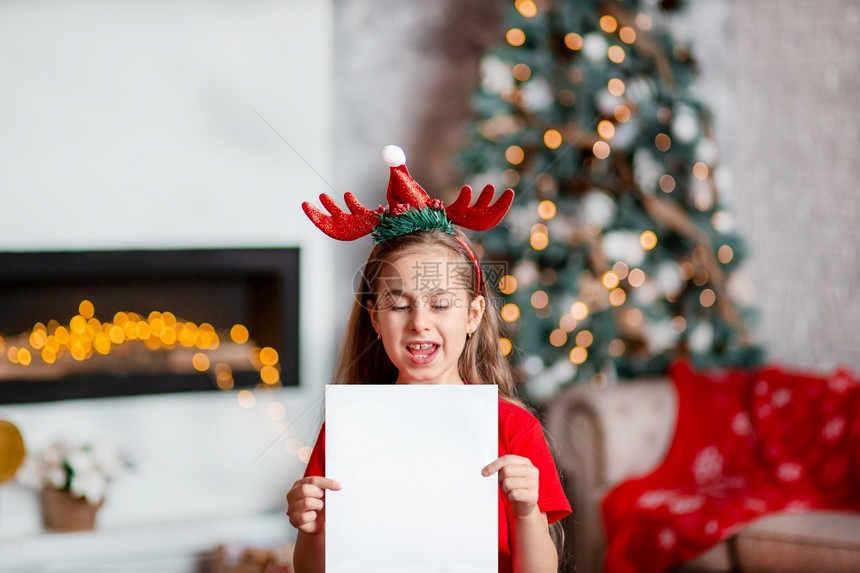头戴圣诞装饰的可爱女孩居家写信图片