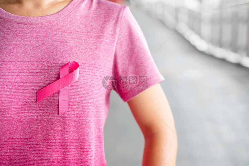 身穿粉红色T恤的妇女佩戴粉丝带图片