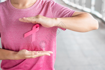 身穿粉红色T恤的妇女佩戴粉丝带预防癌症图片