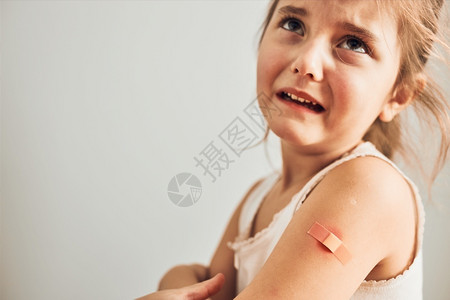 接种疫苗后感到疼痛的小女孩背景图片