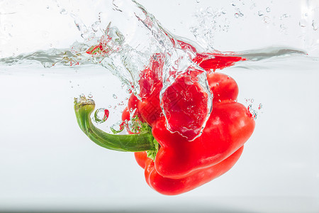 降低营养甜辣椒在水中喷洒红辣椒在白色背景的面上加红甜辣椒是一种不品尝图片