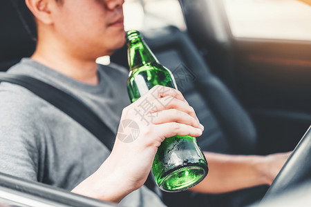 男人违反醉酒子驾驶一辆汽车在路上载着啤酒瓶的车危险醉酒驾驶概念事故背景