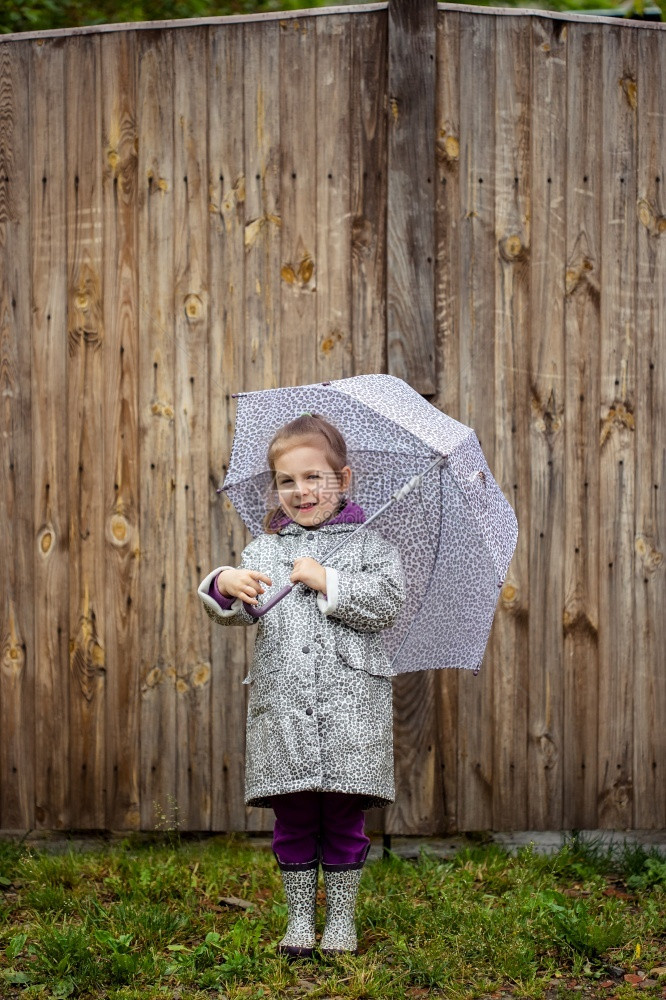 外套夏天走在雨中的小女孩打着雨伞水坑夏天走在雨中的小女孩打着雨伞衣公园图片