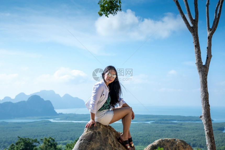 徒步旅行景观坐在泰国SamedNangChee的PhangNgaBay山顶上的年轻女子人们图片