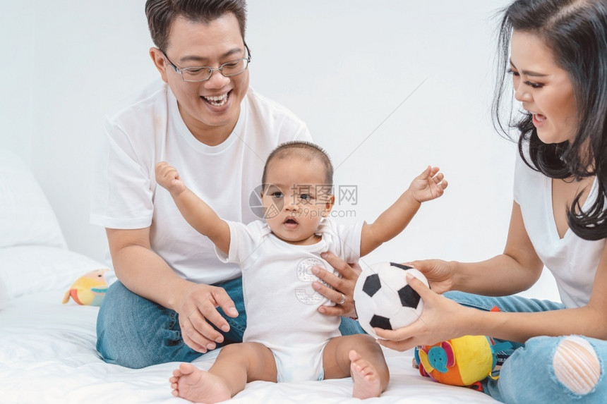 亚洲幸福家庭在中卧室与父亲和母在一起的男孩子亚洲幸福家庭场景生活方式概念东南关心欢呼图片