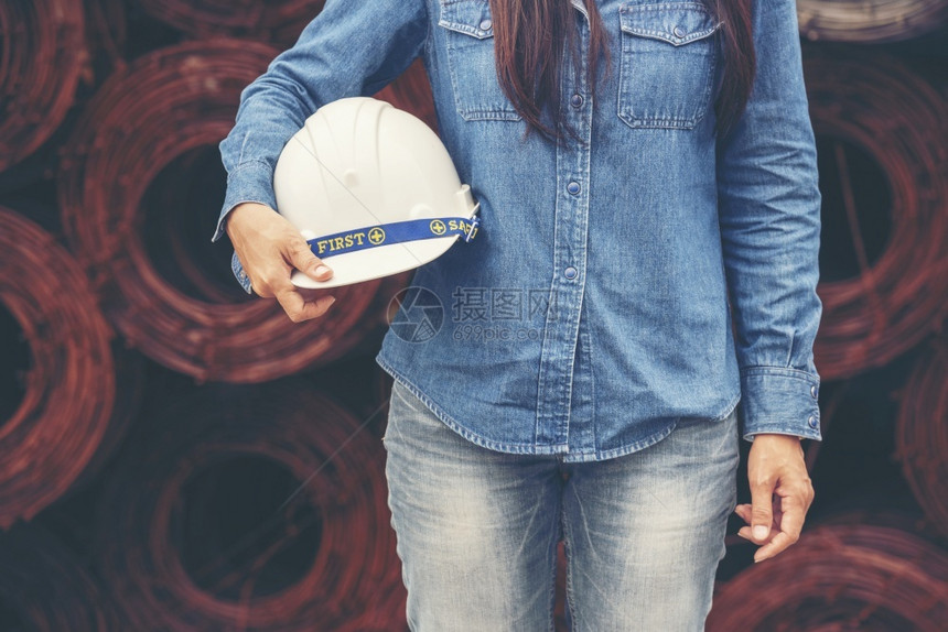建造屋安全帽女建筑工程师在地身戴安全白色钢帽的建筑工场薪女程师土木带有硬帽子安全头盔的女建筑工程师概念a妇女建筑工程师图片