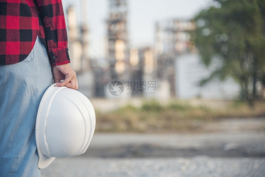 劳动女建筑工程师在地身戴安全白色钢帽的建筑工场薪女程师土木带有硬帽子安全头盔的女建筑工程师概念a妇女建筑工程师在职的训练图片