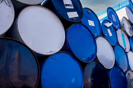 特写旧化学品桶蓝色和白油桶钢罐有毒废物仓库危险化学品桶旧中的工业废物厂中的危险废物储存金属桶安全有毒的股票背景图片
