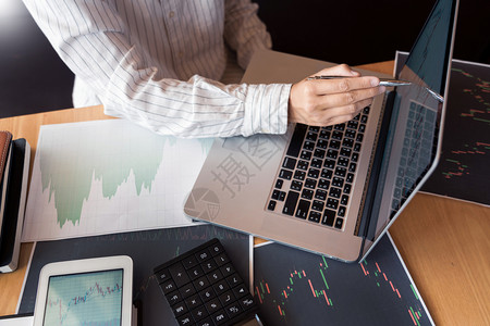 外汇专业的经纪人或贸易商的经工作人在股票市场的多台计算机屏幕上考虑前头ex投资交易金融图表数据分析的商人背景
