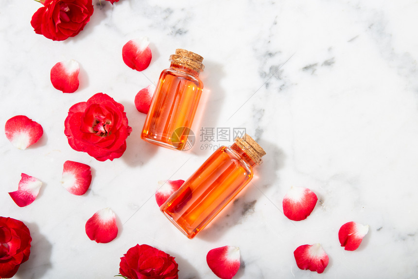 滴管自然玻璃瓶和有花瓣的小红玫瑰香水中含有腐烂的玫瑰水闻图片