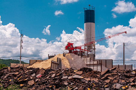 建造在混凝土合工地沙石堆上停车的Crane以沥青混凝土为前景合器加强图片