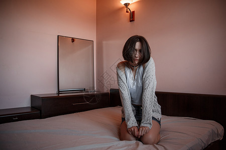 独自的短一个穿裙子年轻女孩和白衬衫坐在床上面脸伤感痛又体贴悲背景图片