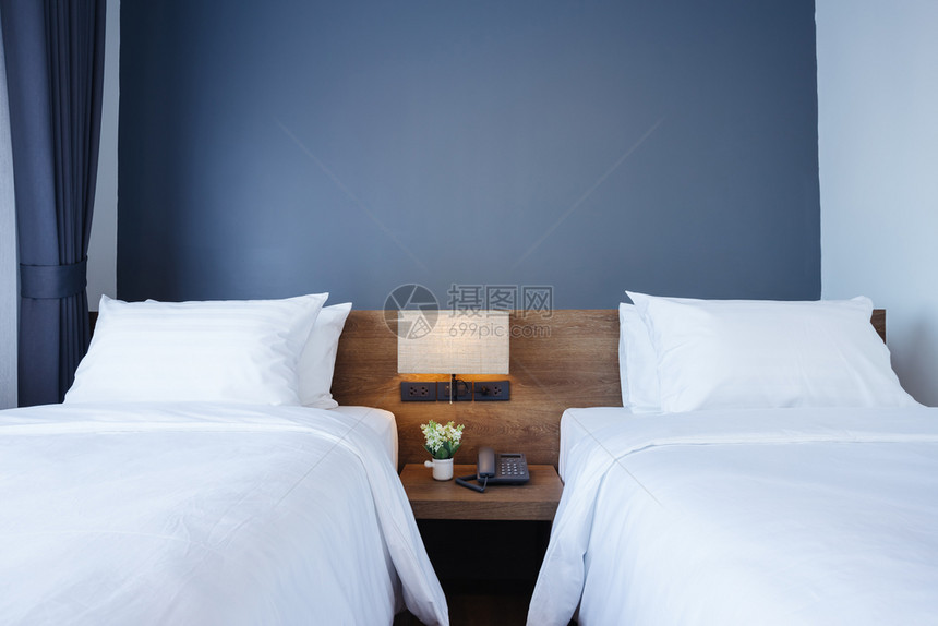 酒店在床上装饰的白色枕头上加灯和在旅馆室内卧安装数字电话的白枕头柔软住宅图片