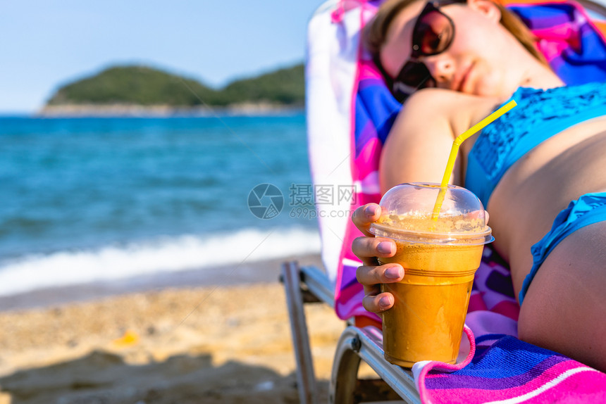 紧贴着女手在海滩上握着一块薯条或冰咖啡同时在阳光明日的度假晒太阳时放松尽管饮料户外图片