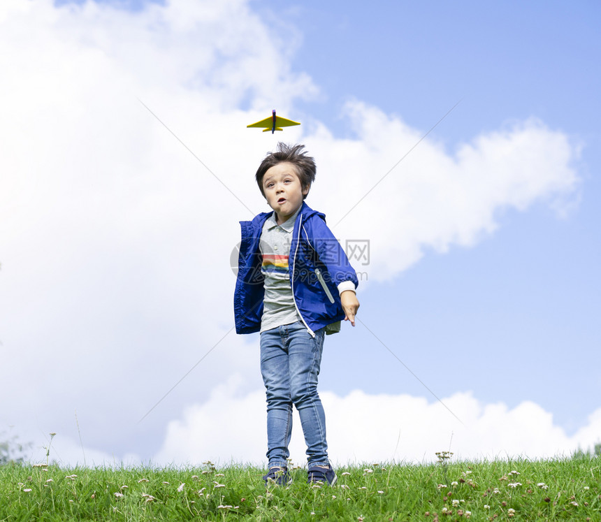 兴奋的快乐年轻生动活跃小男孩在绿色自然背景下玩具飞机儿童投掷泡沫飞机儿童在公园玩耍儿童户外活动概念儿童户外活动图片