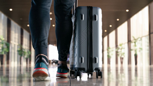 白色的旅行者携带李手提箱随走乘客在机场候站乘坐飞出行的旅客建造空气图片