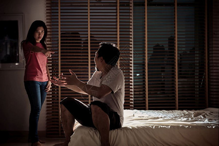 秀智演绎争吵西班牙裔丈夫和妻子在黑暗卧室的床上争吵环境低轻概念戏剧情节深刻气氛极差低的亚洲背景