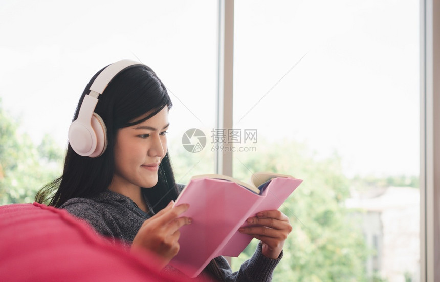 美丽的技术清晨坐在沙发上读一本书在客厅听音乐的同时却在客厅里听音乐阅读图片