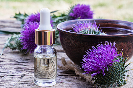 肝脏淋巴植物木本底的一瓶锡或香水和甘油及花以木制背景背景图片