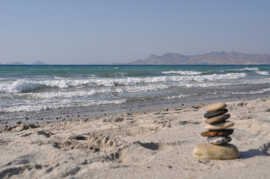 夏天温泉散焦美丽的科斯海滩和无焦点的石块堆希腊土耳其背景图片