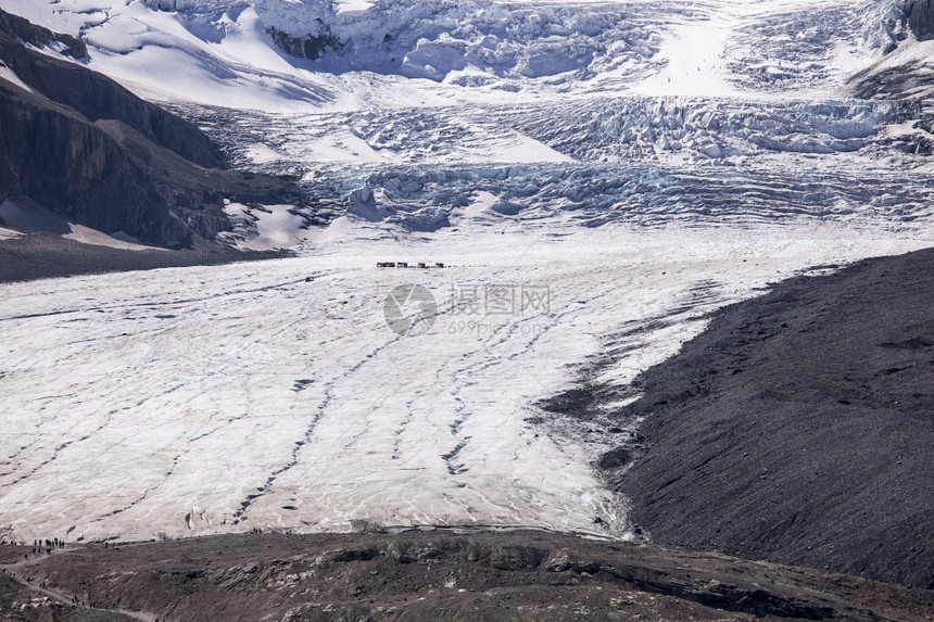 颜色阿塔巴斯卡冰川是由哥伦比亚冰雪田的落形成规模巨大可以显示其规模有一群卡车和人员在悬崖中还有第二组人位于冰川舌头上据说冰川深8图片