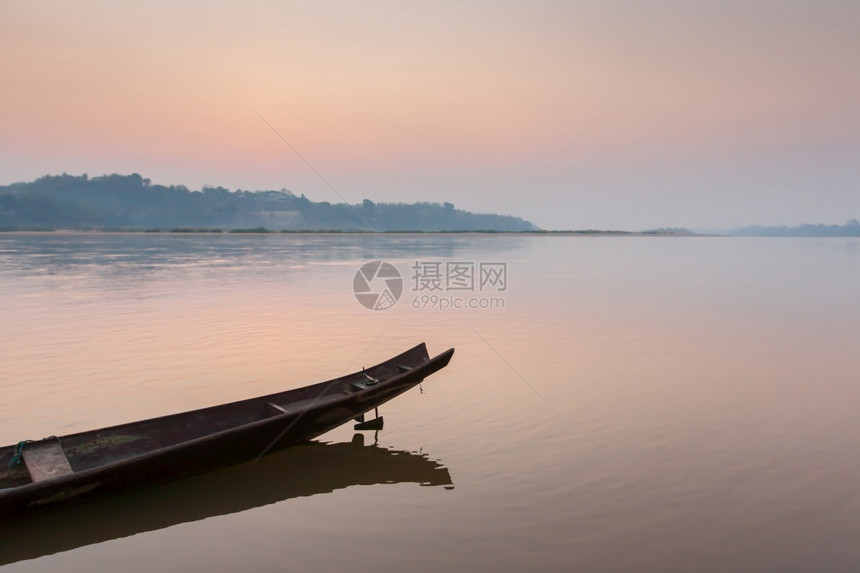 舒适清晨在湄公河岸上一艘传统的木船日出时空反射泰国劳斯河边界的海面关注船只钓鱼黎明图片