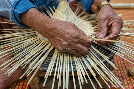 爱好老工匠手的编织大竹和小制造古老手工艺品传统泰式木帽人们活动图片