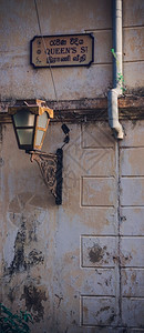 路灯街道钢和Queenrsquos街牌在一堵生锈的墙壁上复古图片