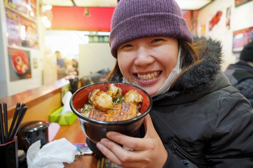 哪一个午餐女孩亚洲年轻享受日本菜美食在鱼市东京日本的碗里有大米和虾图片