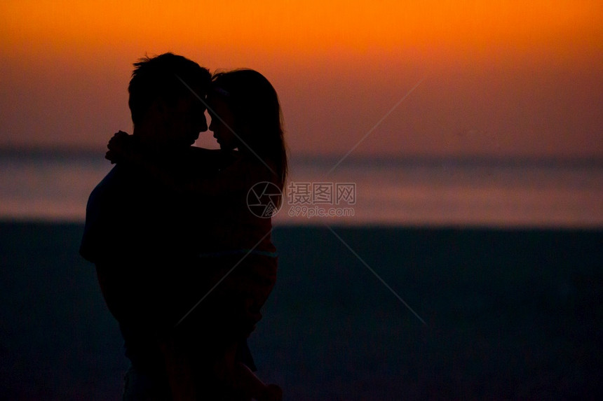 爸爸和女儿在海边享受日落图片
