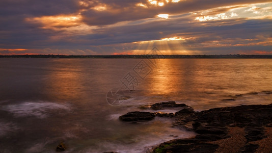 在岩石海岸的美丽日落在岩石海岸的日落浪美丽沿图片