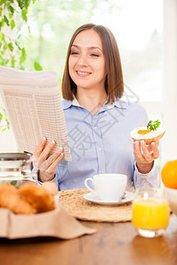 金融茶女商人在吃早餐时看报纸正在人们图片