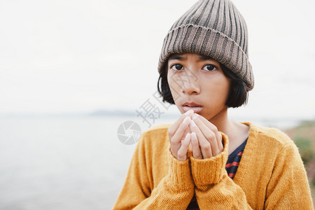 童年户外轻的冬季清晨亚洲小女孩在河上戴羊毛帽背景模糊图片