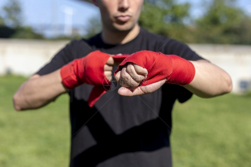 拳击运动员包装准备在户外用前臂绷带训练的拳手图片