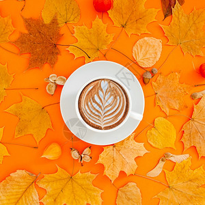 多色秋叶上的咖啡拉花图片