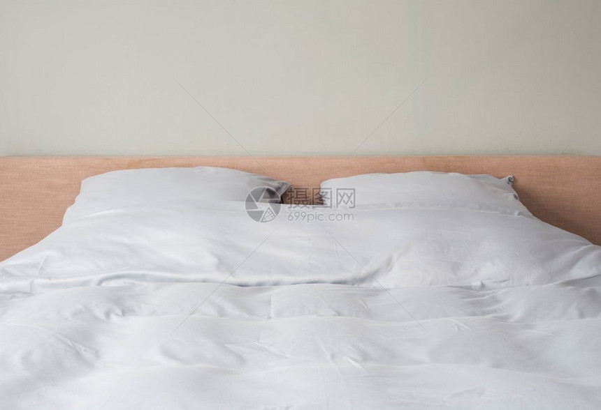 床铺用干净的白色枕头和在房间里的床单制成更接近现代设计床铺用干净的白色枕头和在房间里的床单制成汽车旅馆窗户停留图片