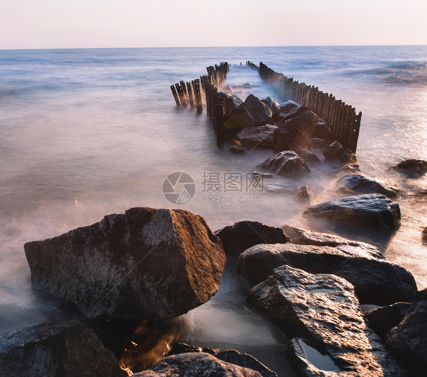 夏季风景海边有粉红日落天空海滩上还有石头在海面建造最微小的风格户外夜晚紫色的图片