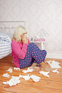 有粉色睡衣和纸巾的生病妇女坐在地板上躺床成人生病的组织图片