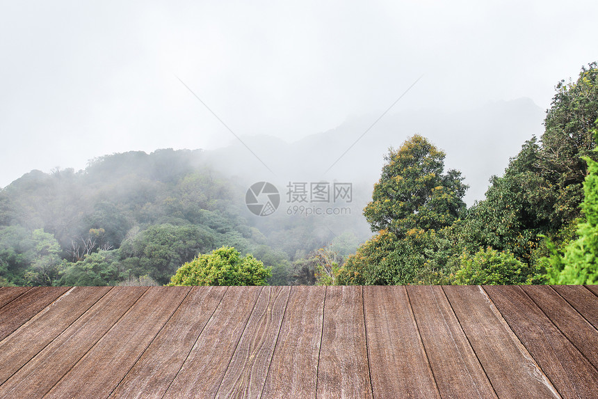 配有山雾背景的木桌浅褐色颜用于蒙合产品显示或设计关键视觉布局和模糊森林视觉的图片