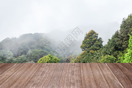配有山雾背景的木桌浅褐色颜用于蒙合产品显示或设计关键视觉布局和模糊森林视觉的背景图片