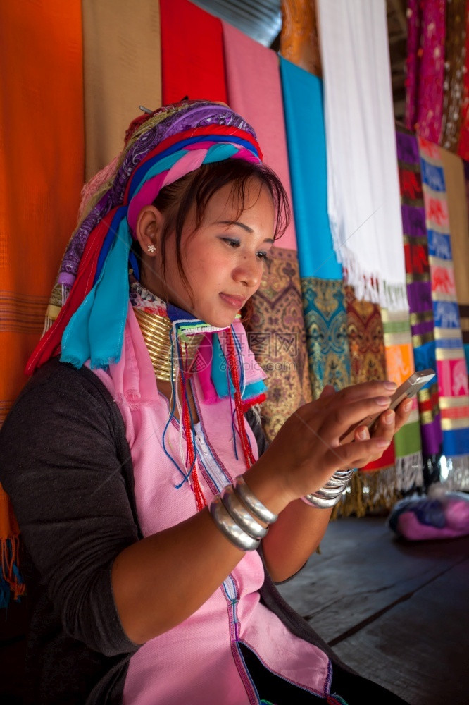 微笑电影土著在村里编织时妇女穿着传统用移动电话的手机在村里穿传统衣服图片