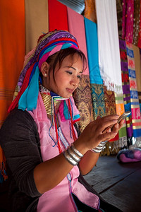 微笑电影土著在村里编织时妇女穿着传统用移动电话的手机在村里穿传统衣服图片