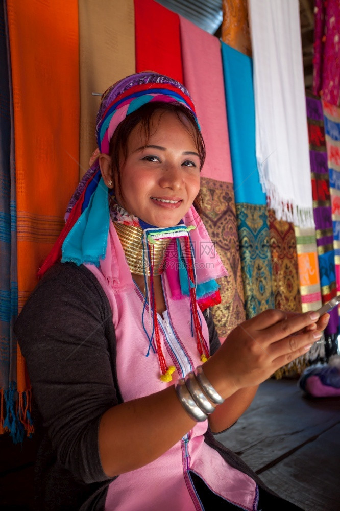 微笑亚洲身体在村里编织时妇女穿着传统用移动电话的手机在村里穿传统衣服图片
