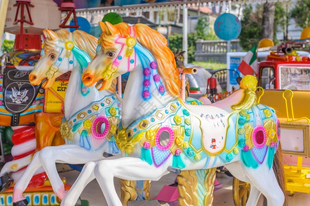 让狂欢更痛快怀旧的儿童游览场两匹马骑在儿童游乐场的旋转木马上狂欢制的背景