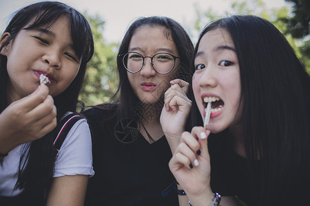青年学校美丽的一群亚裔青少年在休息和吃零食图片