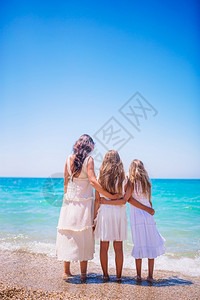 海滩妈和小女孩在沙滩上度假可爱的小女孩和年轻妈在热带白色沙滩上女士图片