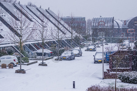 城市的风暴尖在寒冬日暴风雪下冬季现代杜奇人社区在村庄街道上背景图片