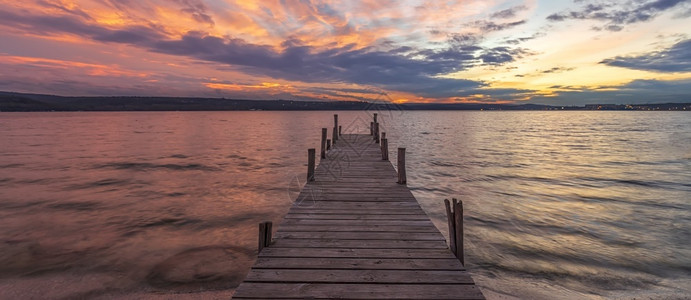 丰富多彩的高超在木制码头湖边的日落多彩的横幅海图片
