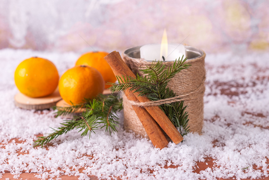 健康普通话和蜡烛放在雪的木背景上甜柑橘图片